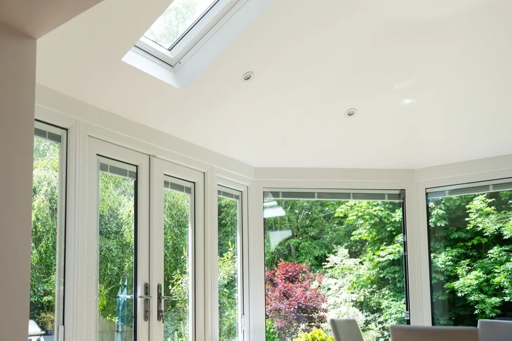 Conservatory interior with a plastered ceiling and Velux window